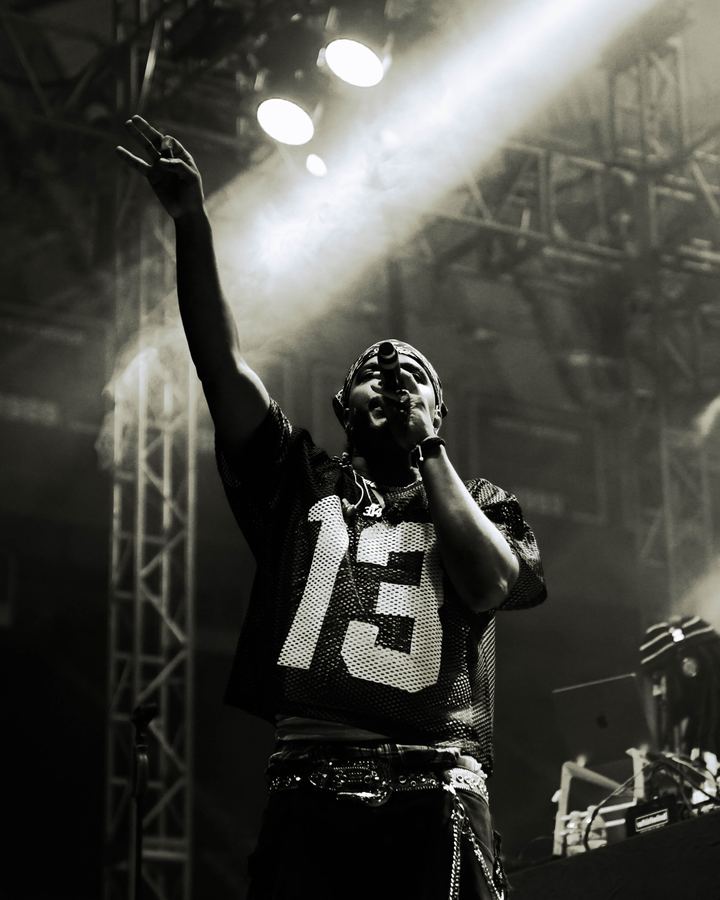 Concert photography - performer raising hand with dramatic stage lighting