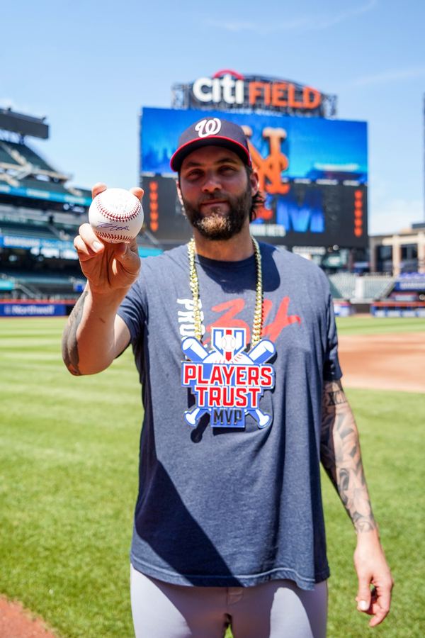 MLBPA - MLB player holding signed baseball at Citi Field